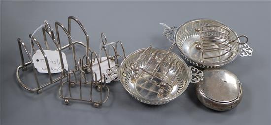 A set of four silver toast racks, another toast rack, a pair of George V pierced silver bon bon dishes and a tobacco box.